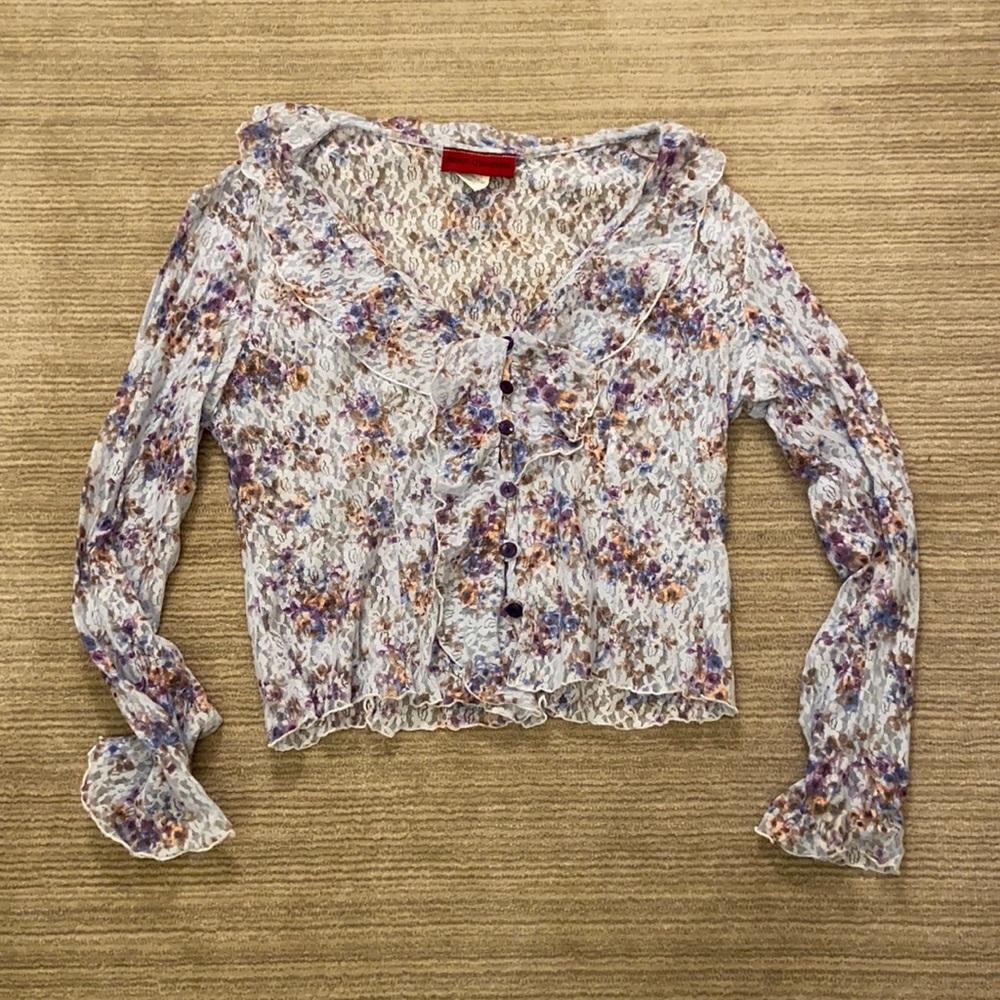 Beautiful lacy blouse accented with ruffles around a v- neck.